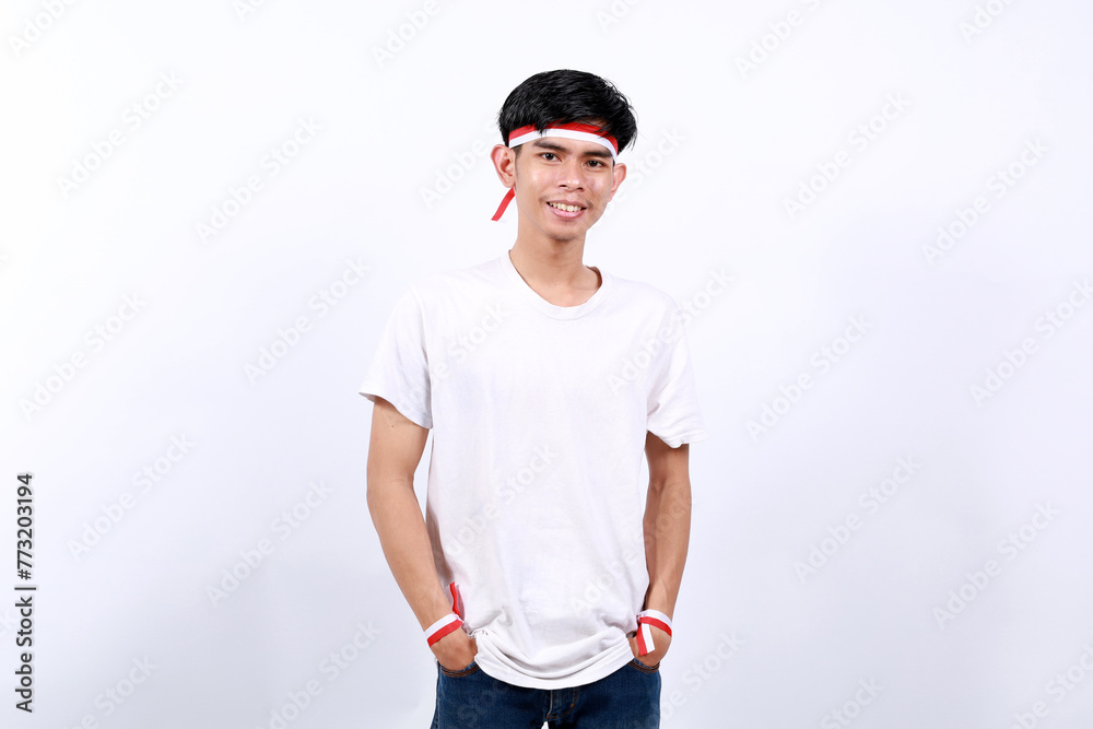 Smiling Asian boy standing celebrating indonesia independence day with red white ribbon Smiling Asian boy standing celebrating indonesia independence day with red white ribbon
