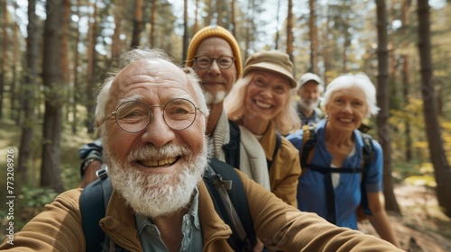 A group of senior citizens in retirement on a forest trek together in summer, taking pictures and smiling together. Nature, selfie and a group of seniors hiking together for wellness and exercise in photo