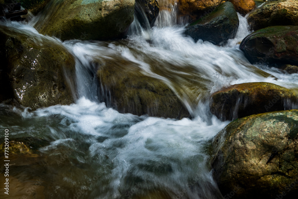 Long exposure image of stream water with rocks Long exposure image of stream water with rocks