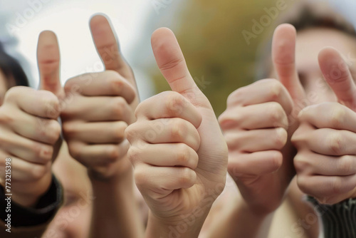 In this photo, a group of individuals are giving a thumbs up as a symbol of agreement or satisfaction, with a defocused background © Fxquadro