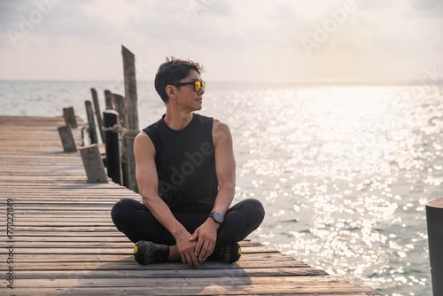 young man with sun glasses enjoying sunbathing at the beach. man with beautiful smile on a background of a turquoise tropical sea in a resort, travel and lifestyle concept.
