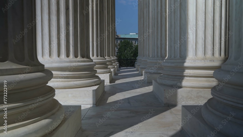 Very large towering columns in front of US Supreme Court building in Washington, DC showing judicial power over people and business. Very large towering columns in front of US Supreme Court building in Washington, DC showing judicial power over people and business.