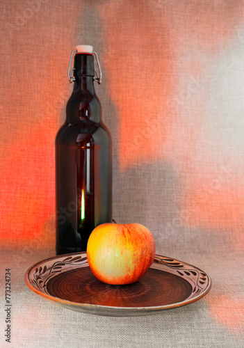 Still life indoors with a refreshing apple and a bottle of your favorite drink. The contrast between them is simply amazing.