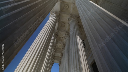 Very large towering columns in front of US Supreme Court building in Washington, DC showing judicial power over people and business.