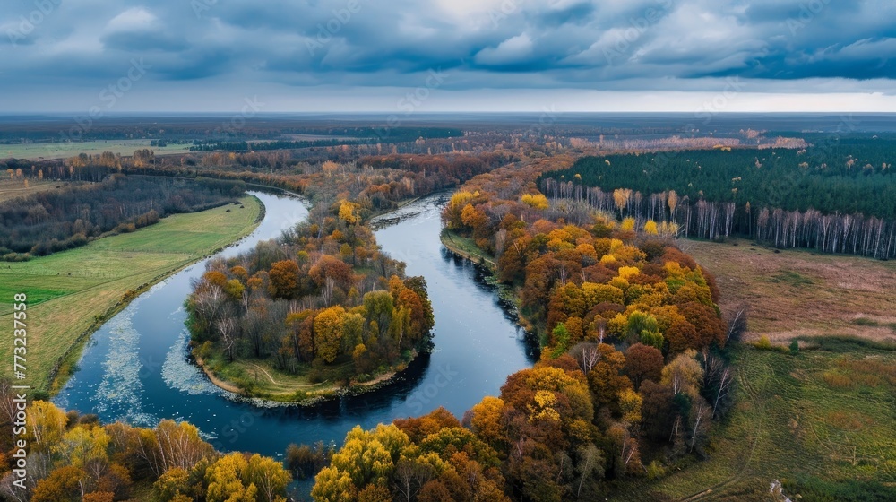 The picture is a drone image showing an aerial view of a rural area in Latvia during autumn. It