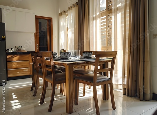 Dining room table with a glass top and wooden chairs in an Indian home