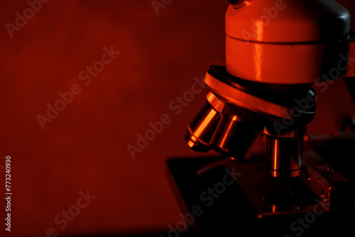 Medical microscope lenses close up, In warm red lighting