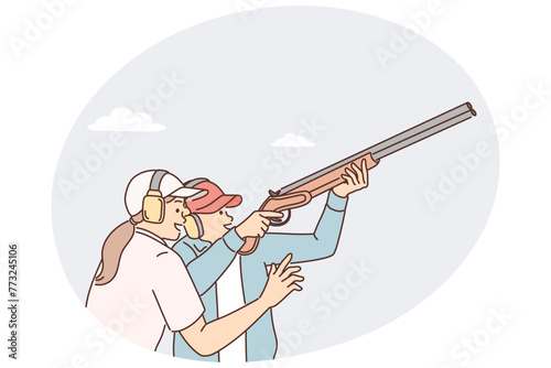 Man learns how to hold rifle and shoot cymbals with firearms under supervision woman trainer