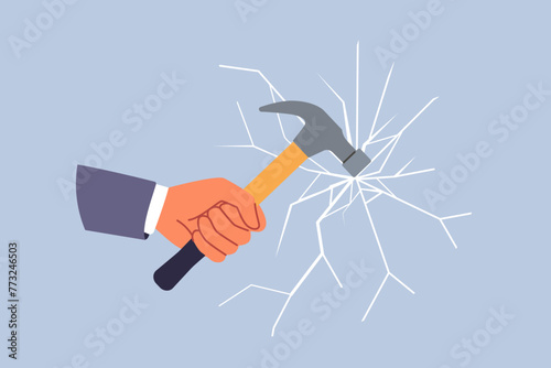 Glass breaks from blow from hammer held by hand of man trying to destroying unnecessary mirror partition. Concept of destroying barrier or vandalism during office robbery through window