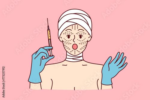 Woman is preparing for facelift procedure, and opens mouth, shocked by prices for plastic surgery, holds syringe in hands. Girl patient at plastic surgery clinic with bandaged head and lines on face
