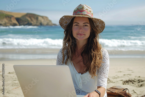 Woman working on her laptop at the beach on a sunny and pleasant day, capturing the essence of the digital nomad lifestyle.