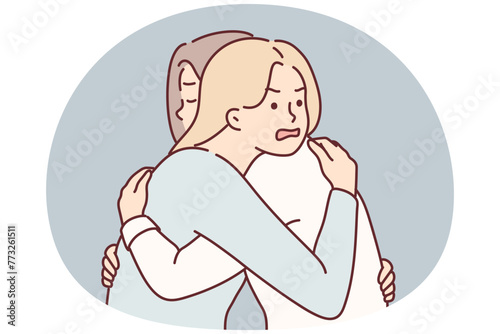 Woman with angry expression hugs girl friend hiding envy or jealousy in order to deceive