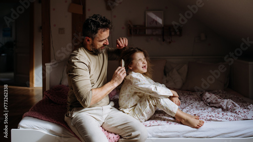 Картината върху платно Father combing and braiding daughter's hair as part of bedtime routine