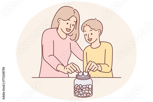Mom and son together throw coins into moneybox, wanting to save up money for cherished wish