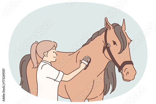 Woman rider takes care of thoroughbred horse by combing animal mane before important races