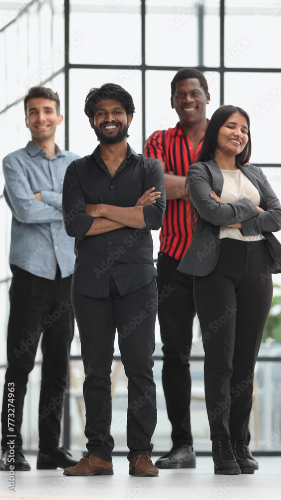 Fototapeta premium Four people stand in the office corridor and look straight ahead.