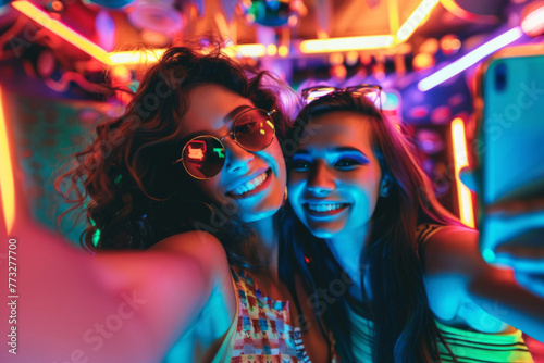 Friends capturing selfies against the vibrant backdrop of nightclub illumination