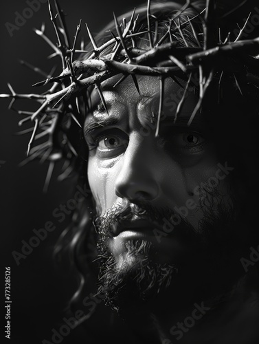 A solemn black and white image of a bearded sculpture with a crown of thorns, looking upwards with an expression of deep contemplation.