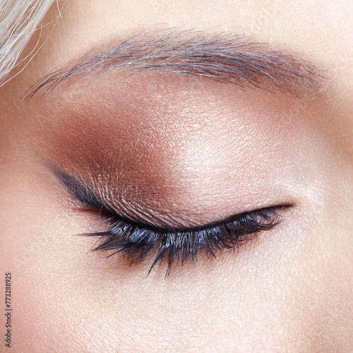 Closeup macro shot of human female closed, eye with black arrows. Woman with natural evening vogue face beauty makeup.