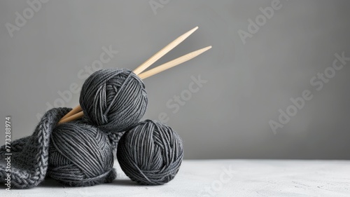 Dark yarn balls and knitting needles on gray. photo