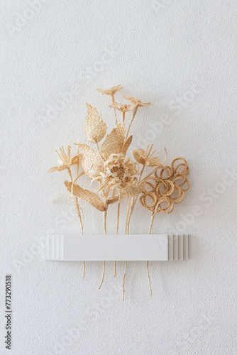 Wall vase for dried flowers. Flowers made from straw on a white background. Straw weaving. Straw wall decoration. 