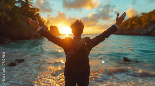 Businessman in suit at sunset on a vacation beach paradise. Concept of work success, triumph or beginning of summer vacation. 