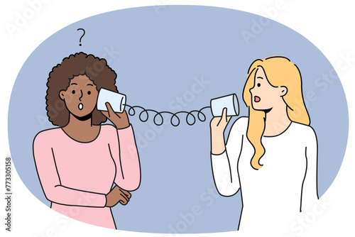 Diverse women talk with tin can telephone have misunderstanding. Multiracial friends speak on handmade can phone having problems communicating. Vector illustration.
