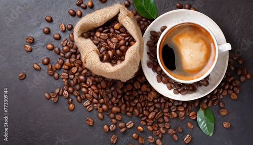  Top view of Cup of coffee and coffee beans in a sack on dark background