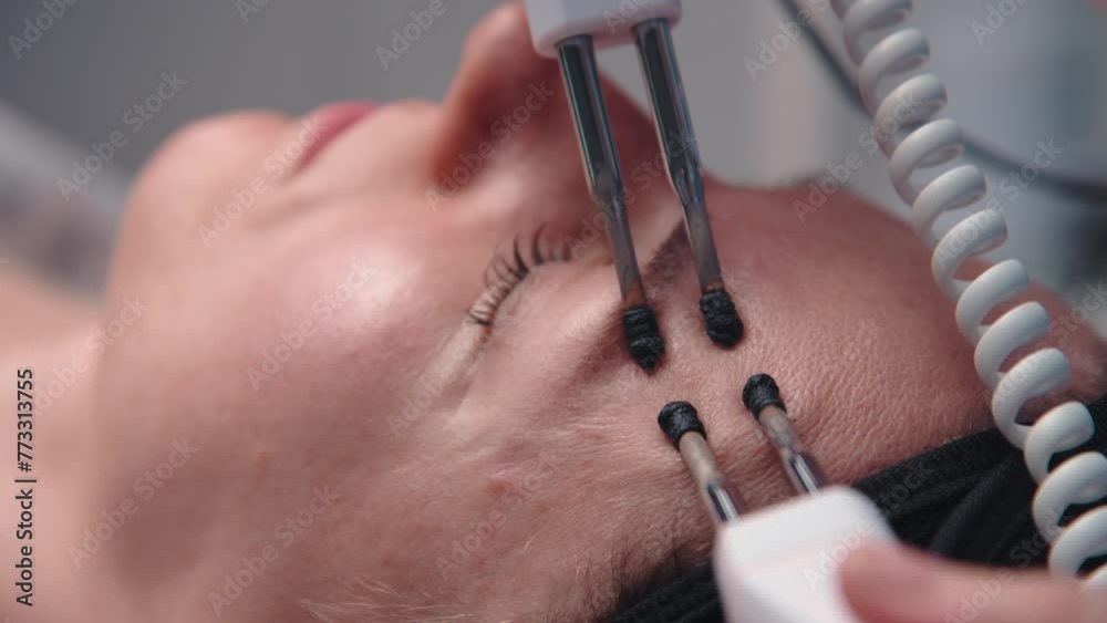 Hardware procedure in cosmetology. Close-up. Non-surgical face skin lifting in beauty clinic. Beautician cosmetologist doctor moving manipula on face. micro-current treatment Hardware procedure in cosmetology. Close-up. Non-surgical face skin lifting in beauty clinic. Beautician cosmetologist doctor moving manipula on face. micro-current treatment