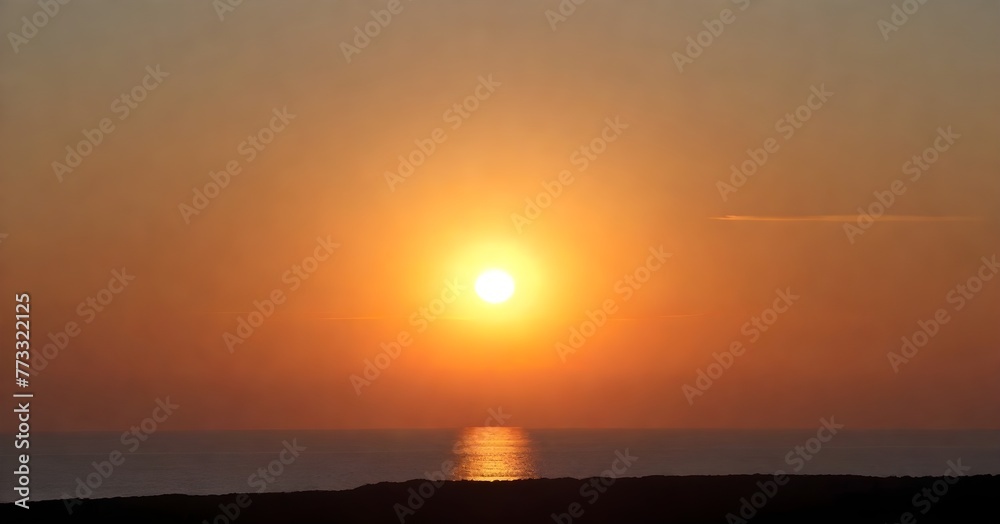 Stunning landscape of a golden sun setting over the horizon of a tranquil blue ocean Stunning landscape of a golden sun setting over the horizon of a tranquil blue ocean