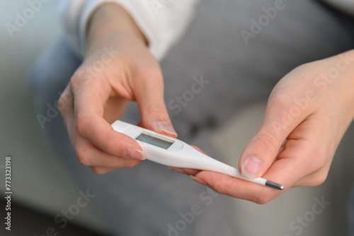 close up view of white thermometer in woman hands