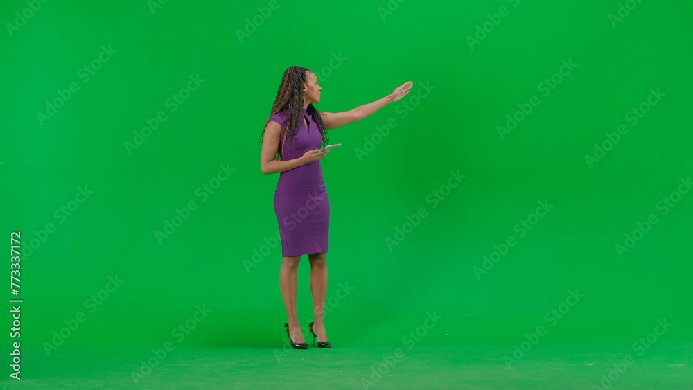 Female in dress isolated on chroma key green screen background. Full shot african american woman tv news host standing talking looking at camera. Female in dress isolated on chroma key green screen background. Full shot african american woman tv news host standing talking looking at camera.