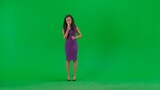 Female in dress isolated on chroma key green screen background. Full shot african american woman tv news host standing talking in microphone looking at camera.