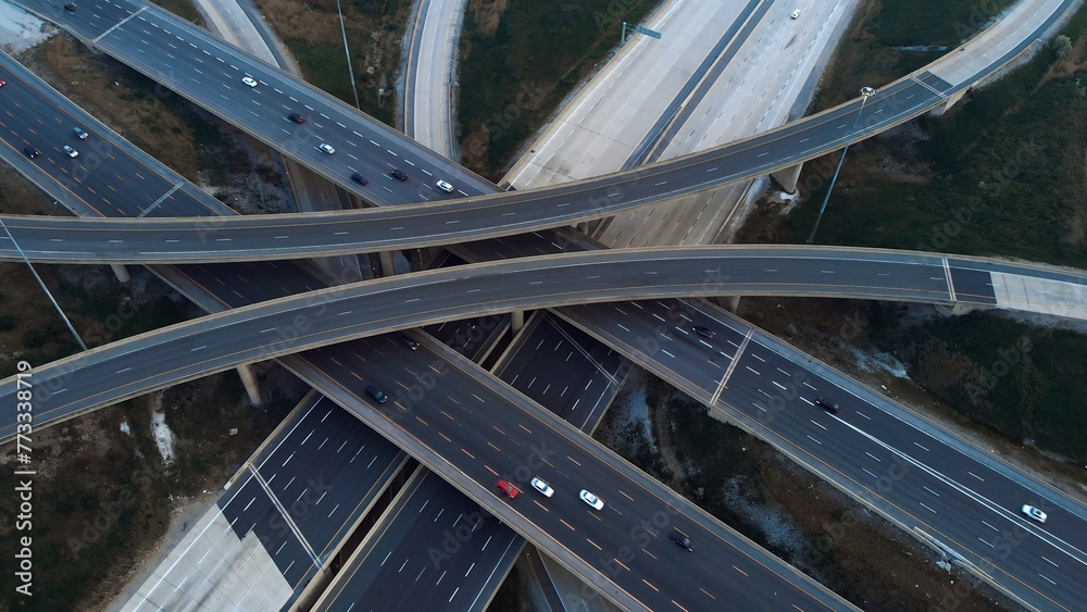 Obraz premium Urban transport connectivity: observing traffic movement on elevated highway network. Freeway efficiency of transport linkage. Cars travel along freeway flow within elevated transportation grid