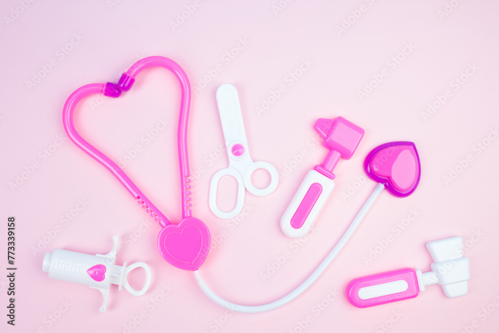 The concept of a pediatrician. Pediatrics. Toy medical devices on a pink background. Children play professional doctor. Choice of profession. Get vaccinated.