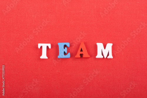 TEAM word on red background composed from colorful abc alphabet block wooden letters, copy space for ad text. Learning english concept.