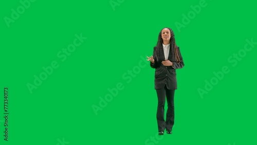 Young female reporter isolated on chroma key green screen background. Full shot african american woman tv news host walking and talking.