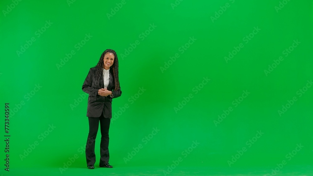 Young female reporter isolated on chroma key green screen background. Full shot african american woman tv news host talking smiling at camera. Young female reporter isolated on chroma key green screen background. Full shot african american woman tv news host talking smiling at camera.
