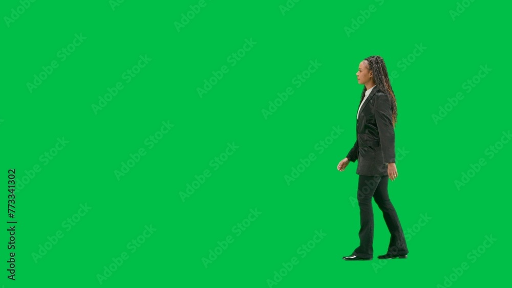 Young female reporter isolated on chroma key green screen background. Full shot african american woman tv news host walking. Side view.