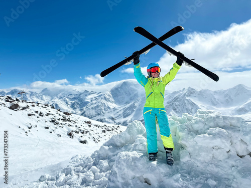 A sportish woman in a skiing suit and sun glasses happy in the mountains