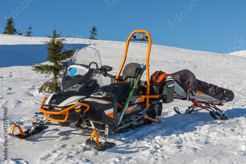 Snowmobile with stretcher mountain rescue service in front of cottage vyrovka in krkonose mountains.