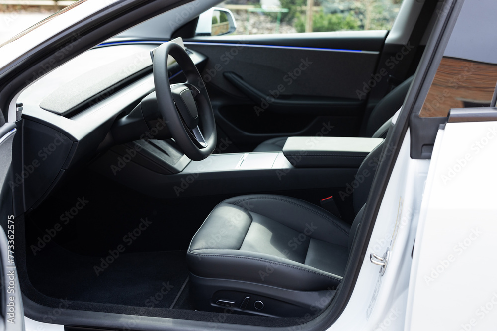 Car interior luxury inside. Steering wheel, dashboard, speedometer, display. Black leather interior. Modern luxury car Interior - steering wheel, shift lever and dashboard