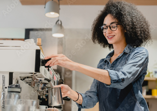 20s afro female barista making coffee using coffee machine in cafeteria, brewing drip filter from quality beans in restaurant behind the bar counter in restaurant