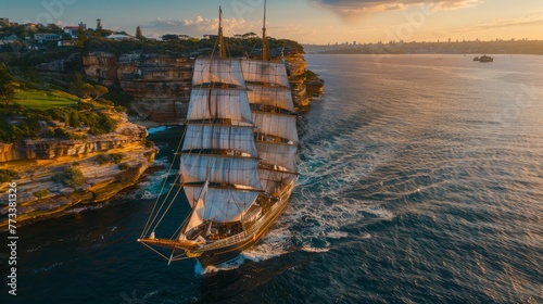 A large historic tall ship, with full sails raised, majestically sails through a body of water