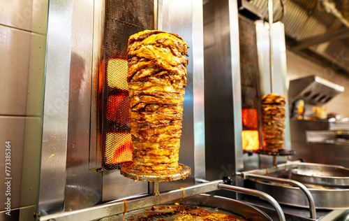 Juicy meat is fried on a shawarma spit. photo