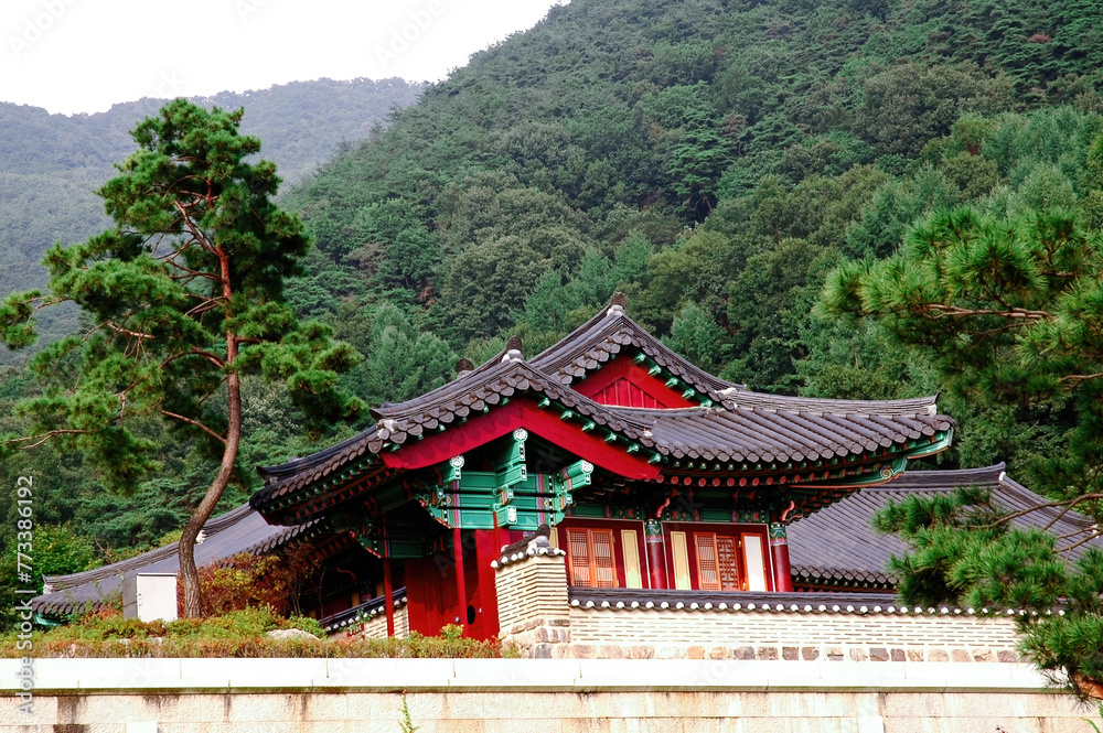 Traditional Korean architecture. Buddhist temple in the mountains. A wooden Buddhist building with a tiled roof decorated with carvings. A place of peace. A symbol of Korean culture.