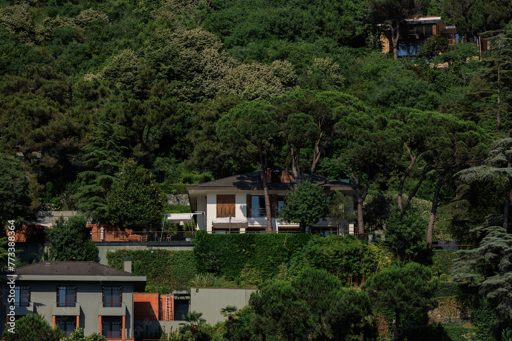 Fototapeta premium Beautiful houses and city streets of the southern city with green plants, public place in Turkey, on a summer sunny day