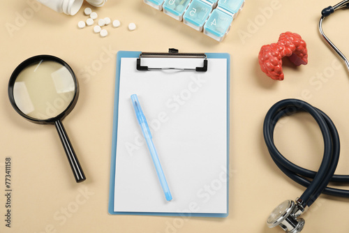 Endocrinology. Flat lay composition with clipboard and model of thyroid gland on beige background