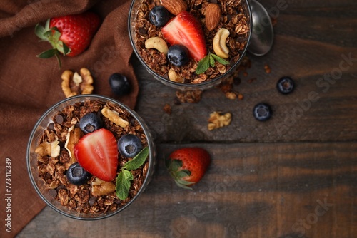 Tasty granola  berries and nuts on wooden table  top view. Space for text