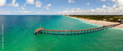 Idyllic summer day over sandy beach at Venice fishing pier in Florida. Summer seascape with surf waves crashing on sea shore photo